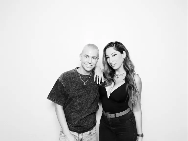 Black-and-white portrait of two guests posing against a white backdrop
