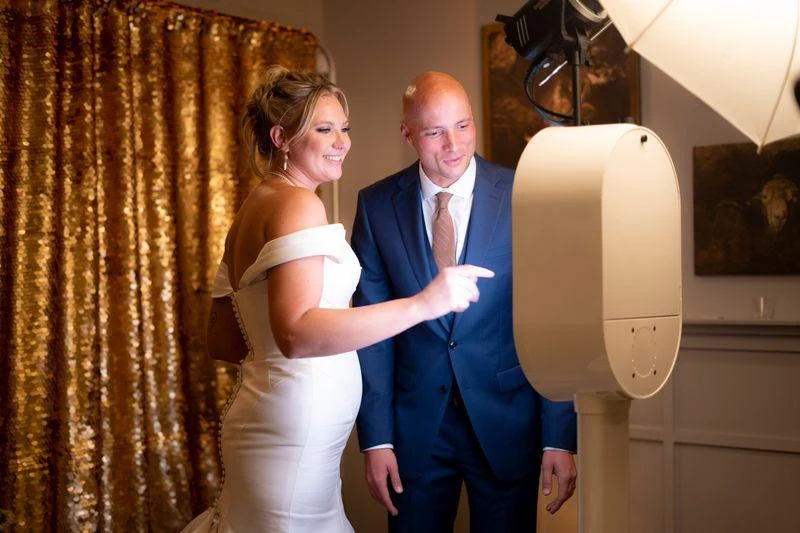 Couple interacting with the screen of a white open-air photo booth