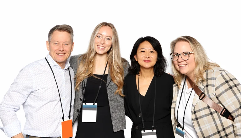 Four corporate event guests posing against a clean white backdrop