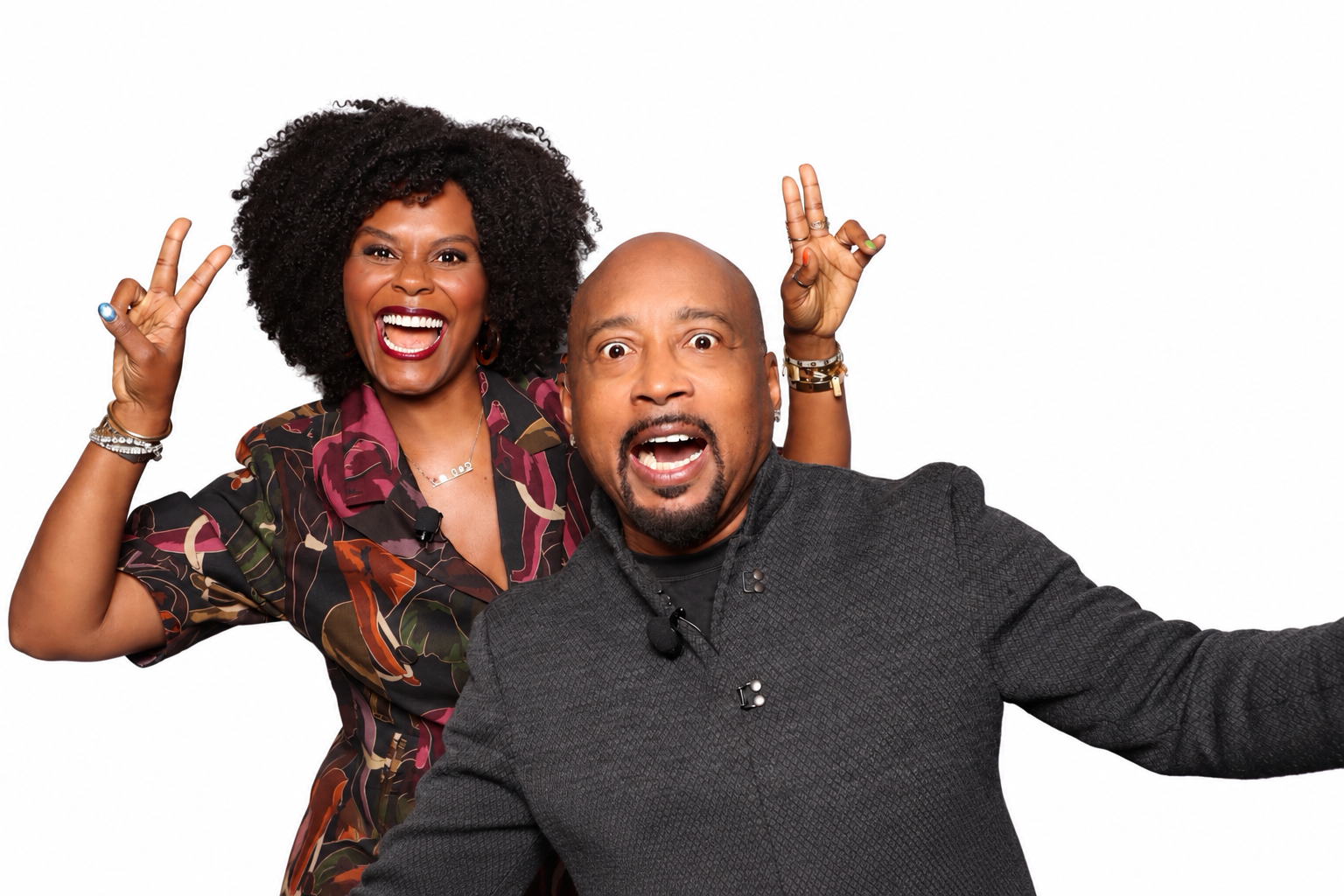 Two guests smiling and posing together against a white background