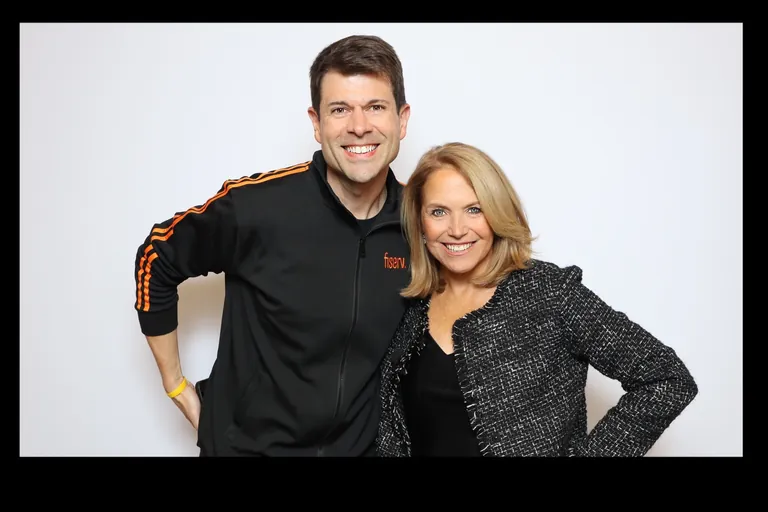 Two guests smiling together against a white backdrop